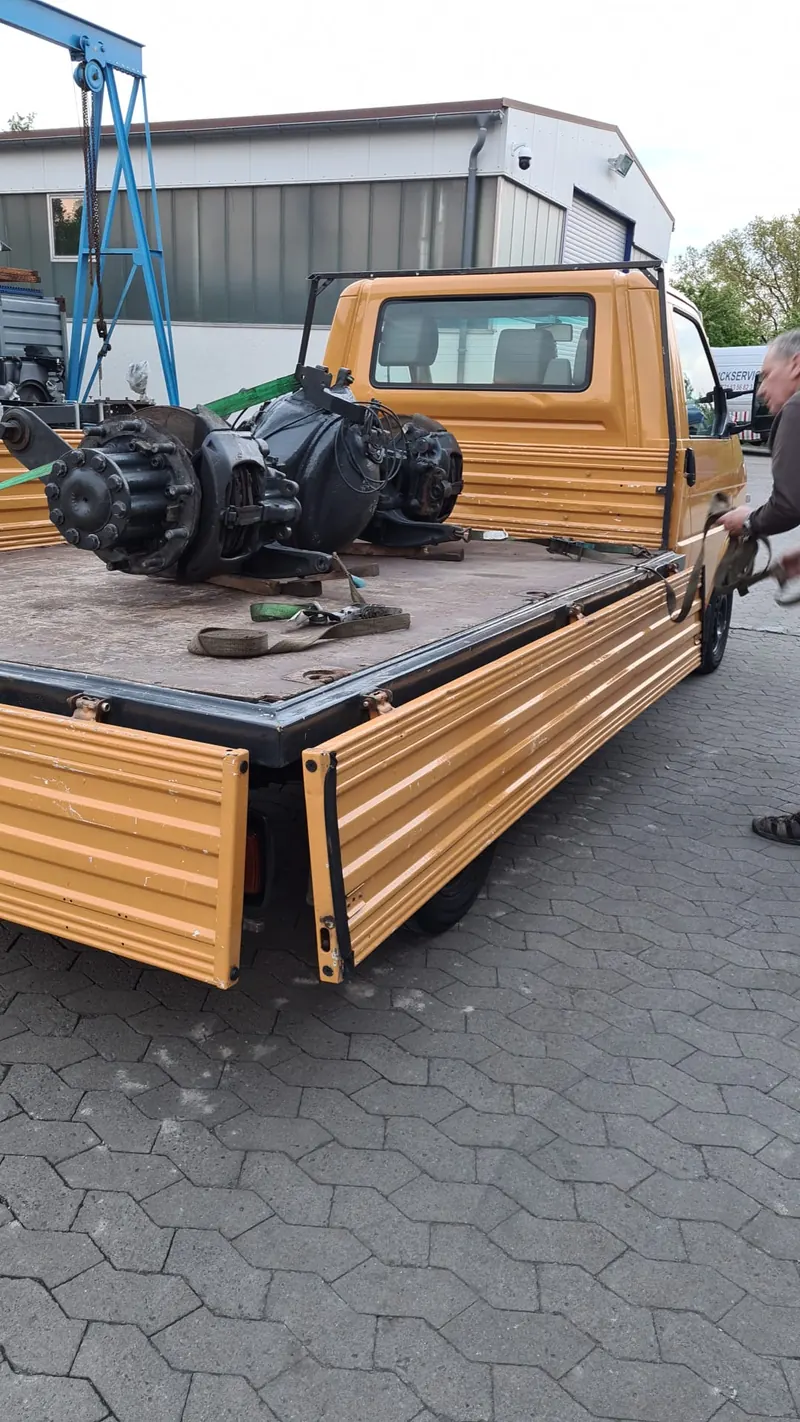 Rear axle on the loading bed of a van in front of the workshop