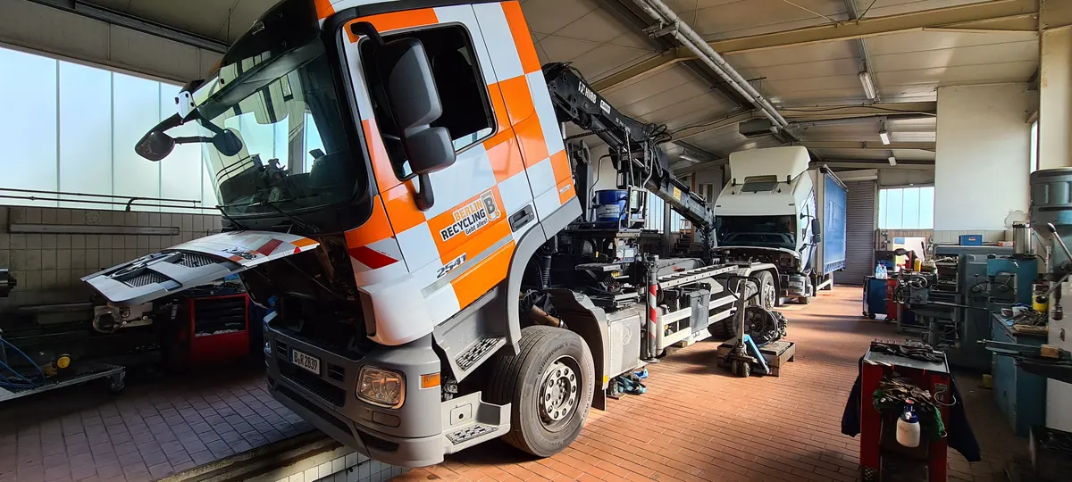Zugmaschine mit Ladekran in der Autowelt-Werkstatthalle